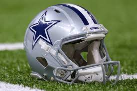 The Autographed Dallas Cowboys Helmet by Hendolph sits on the field.